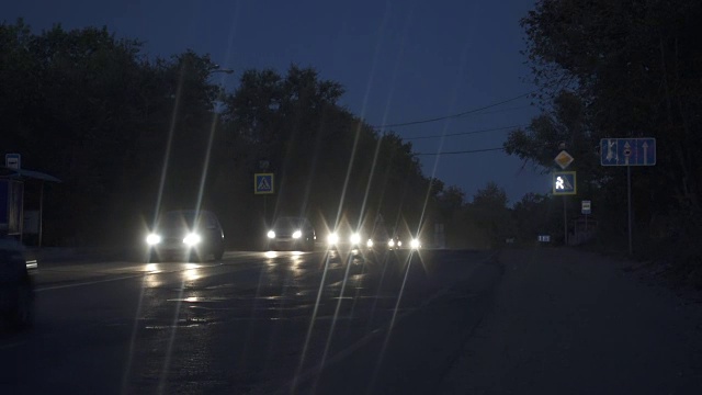 夜晚的城市街道上有汽车。照亮了城市路边的车灯。视频素材