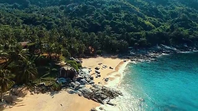 航拍:在努伊岛海滩上的一块大岩石附近起飞。视频素材