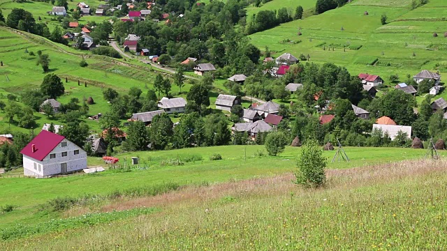 美丽的绿色山丘和红屋顶的小屋视频素材