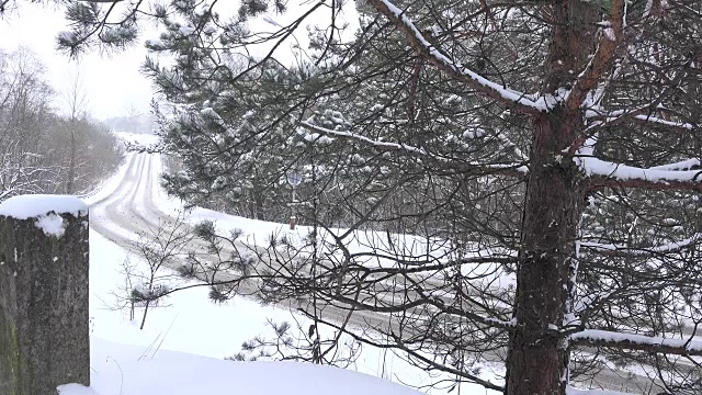 汽车在雪地里行驶在乡村道路上。FullHD视频素材