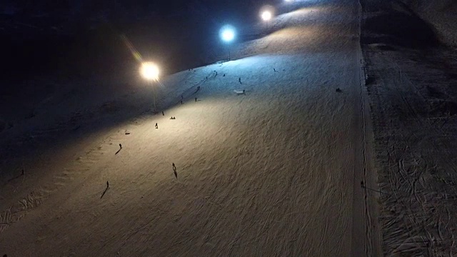 晚上在滑雪场滑雪和单板滑雪。视频素材