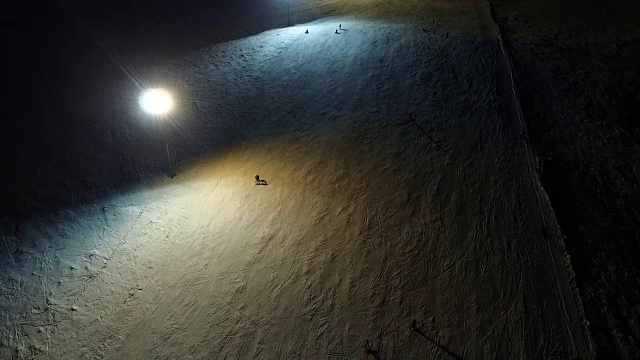 在夜间斜坡上学习单板滑雪。视频素材