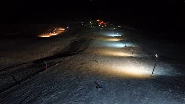 滑雪者在夜间斜坡上耍花样。视频素材