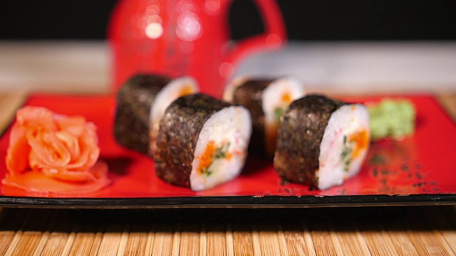 日本寿司放在红色的盘子里，用筷子和源视频素材