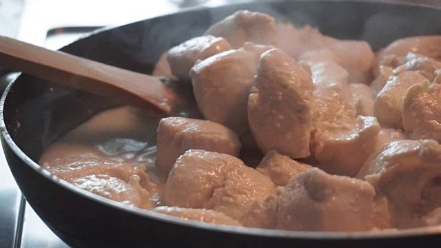 近距离的鸡肉烹饪在煎锅。视频下载