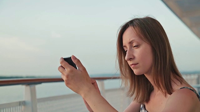 在游轮上使用手机的女人视频素材