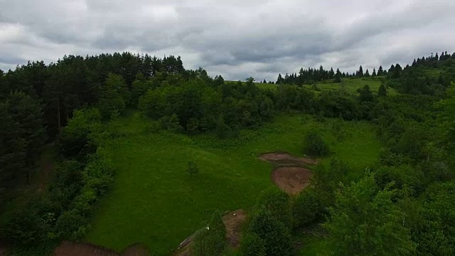 空中飞行飞过绿色的森林山丘视频素材