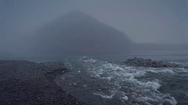 浅清澈的岩石河在单山的底部流在浓雾景观镜头视频素材