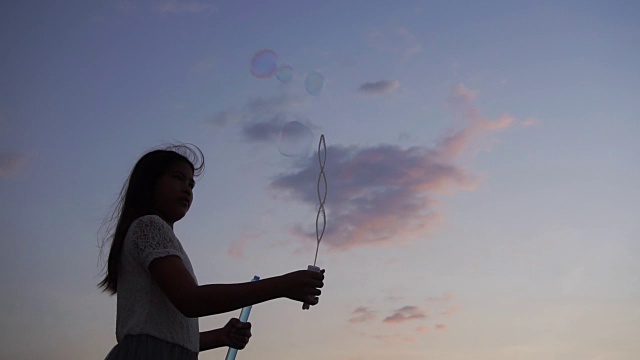 小女孩在夕阳下玩肥皂泡，慢镜头视频素材