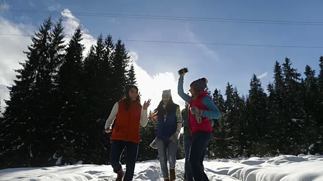 人们群雪林快乐微笑的年轻人朋友在户外冬季松林跑步视频下载