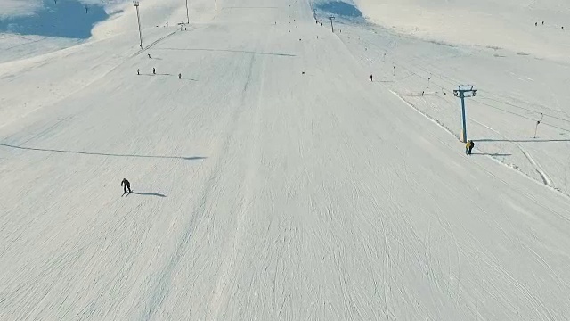 几个人骑着雪坡滑雪，从索道上看在运动视频素材