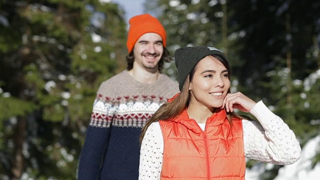 浪漫的夫妇雪森林年轻的男人和女人户外冬季松树林视频素材