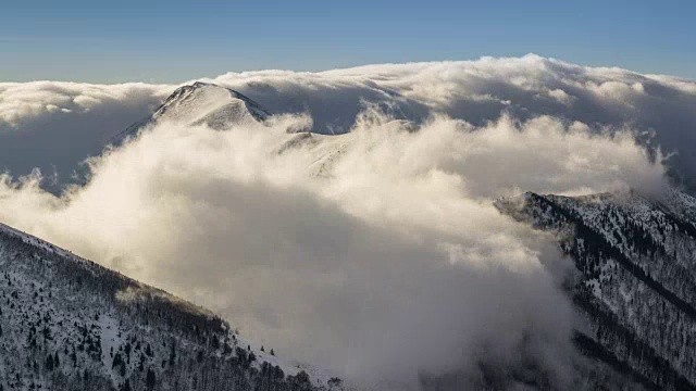 冬天的雪山与低云飞过山脊在晨光时间流逝视频素材