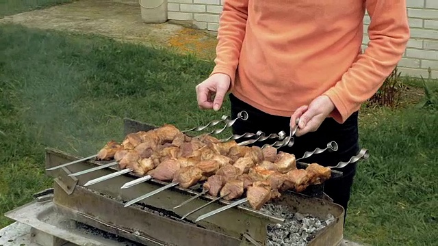 女孩在火盆上用肉烤串视频素材