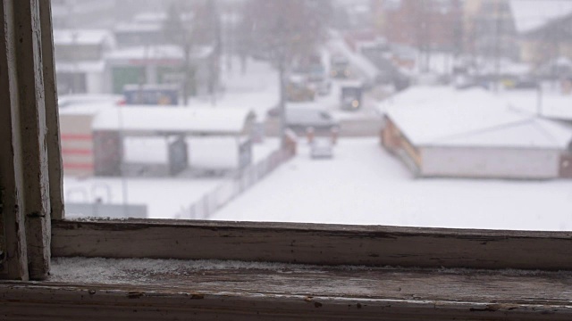 在冬天降雪。旧木窗外的景色视频素材