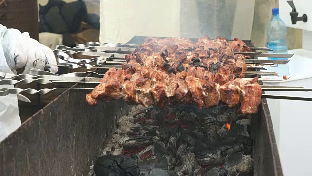 用金属串在炭火上烤猪肉串视频素材