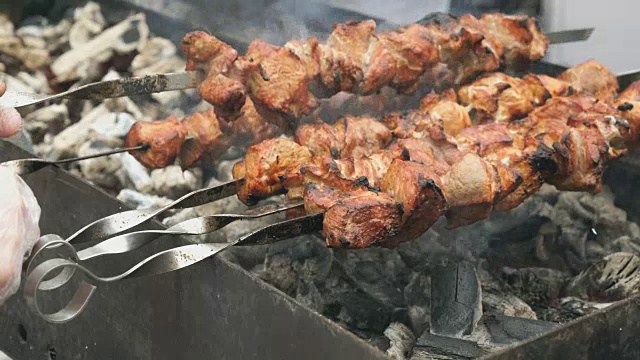 用金属串在炭火上烤猪肉串视频素材