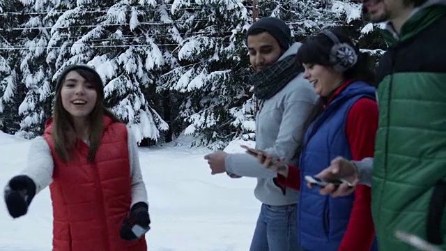 一群女人在冰雪森林里散步微笑的小女孩在雪园里自拍视频素材