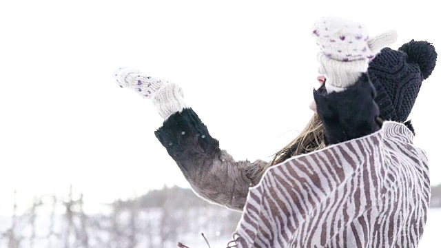 美丽的女孩抛起雪花，在冬日微笑。慢慢地视频素材