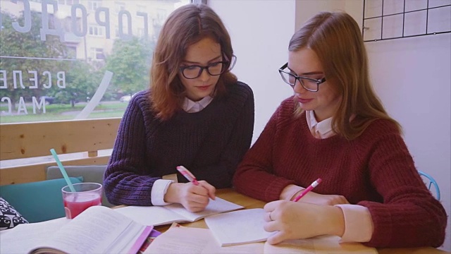 女大学生在咖啡馆学习，两个女孩朋友一起学习视频素材