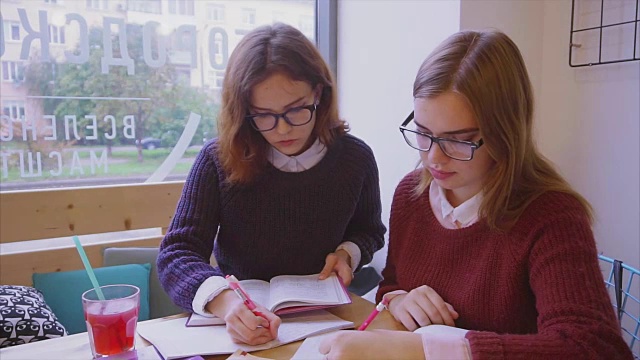 女大学生在咖啡馆学习，两个女孩朋友一起学习视频素材