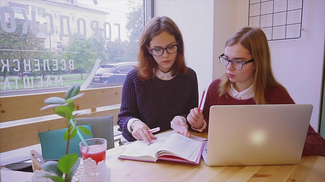 女大学生在咖啡馆学习，两个女孩朋友一起学习视频素材