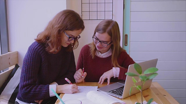 女大学生在咖啡馆学习，两个女孩朋友一起学习视频素材