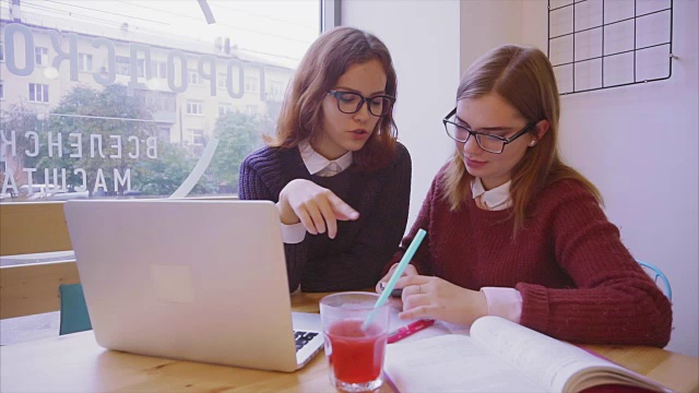 女大学生在咖啡馆学习，两个女孩朋友一起学习视频素材