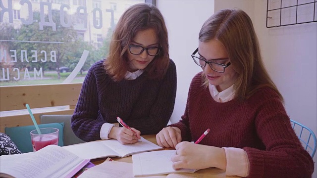 女大学生在咖啡馆学习，两个女孩朋友一起学习视频素材