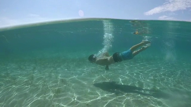 水下:快乐的年轻人在水下游泳，探索神奇的海洋视频素材