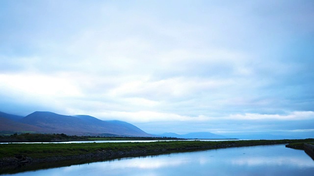 田园诗般的时间推移拍摄的云翻滚的山和湖视频素材