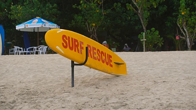 亮黄色和红色的冲浪板躺在巴厘岛的沙滩上。多色冲浪板是站在印度尼西亚海岸的孤独的沙滩上视频素材