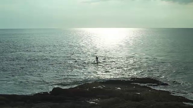 一名男子站在海上的桨板上视频素材