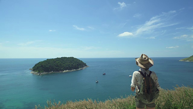 站在海边悬崖上的背包旅行者视频素材