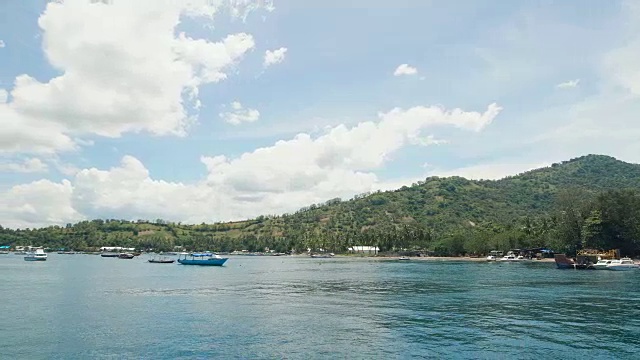 几艘小船停泊在美丽的热带岛屿附近。大海湾，海水清澈湛蓝。系泊游艇、汽艇及帆船视频素材