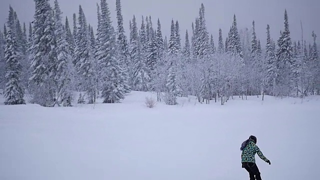 那女孩骑着滑雪板从山上慢慢地下来视频素材