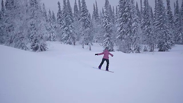 那个女孩骑着滑雪板从山上慢慢地下来视频素材