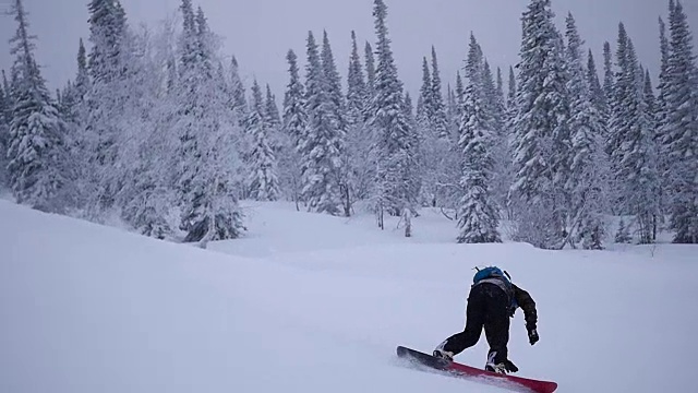 小伙子们骑着滑雪板从山上慢慢地下来视频素材