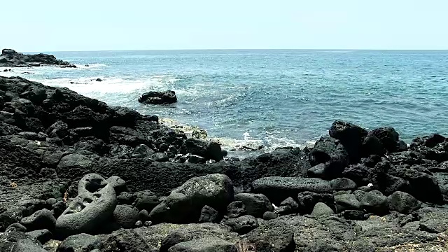 黑色熔岩海滩上的小海浪视频素材