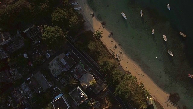 飞过海岸上的房屋和泻湖上的船只视频素材