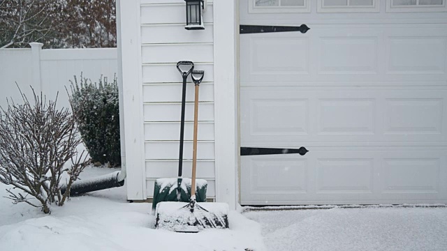 在暴风雪中，铁铲靠在车库上视频下载