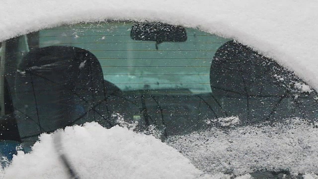 汽车雨刷清除车窗上的积雪视频素材