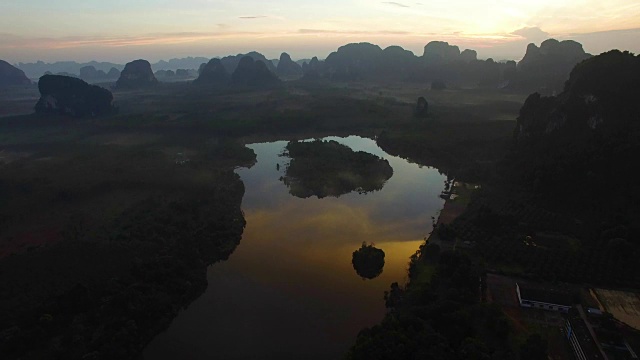 空中:从丛林湖上起飞，日出时可以看到山景。视频素材