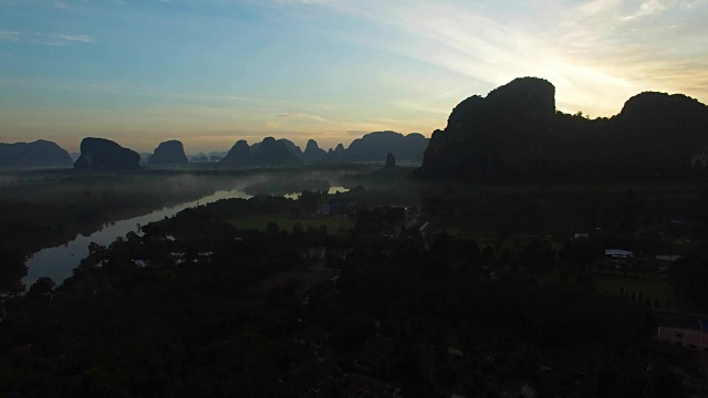 空中飞行:日出时，从浓雾弥漫的丛林中起飞，俯瞰山景。视频素材