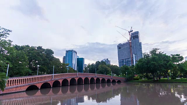 时间流逝拍摄池塘和人行桥在公园日出，夜晚到白天。缩小照片。视频素材