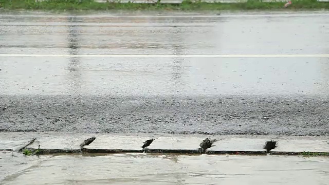 雨点溅落在柏油路上。视频素材