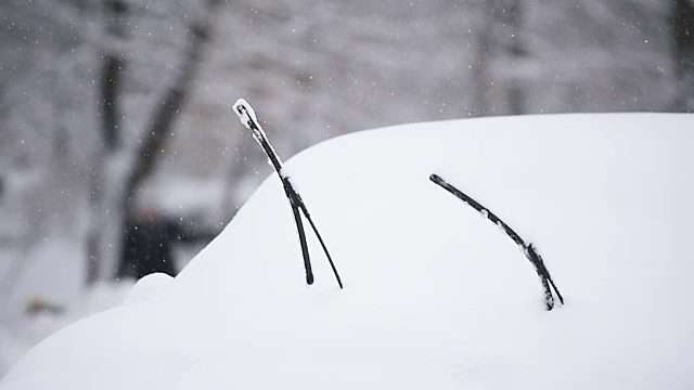 一辆被雪覆盖的汽车的挡风玻璃刮水器视频素材