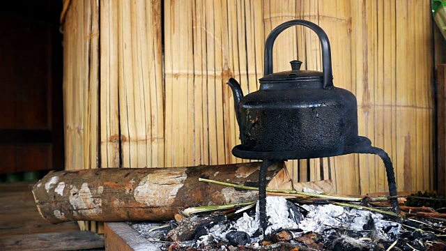 原住民房屋窑炉上复古水壶的慢动作视频素材