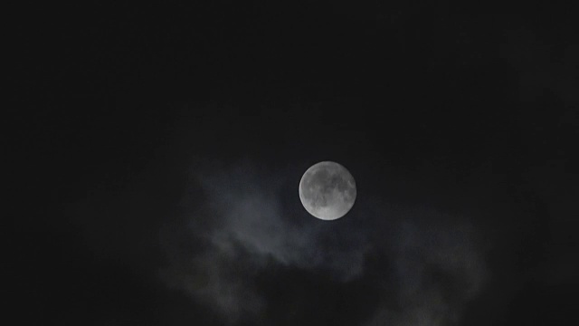 在夜空中，月亮在云的后面，时间流逝。视频素材