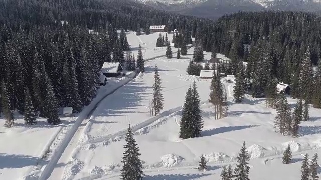 天线:在冬季，通往高原上房屋和高山小屋的被犁过的道路视频素材